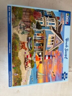 White Mountain Puzzle — Blue Coastal House with Orange Sunset and Red Lighthouse